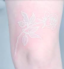 Tatuaje de una rosa en tinta blanca